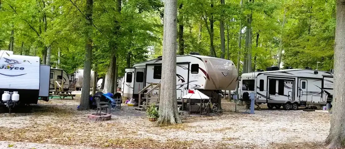 RV campers enjoying a shaded campsite at Woods-N-Waters Kampground in Columbus, Indiana