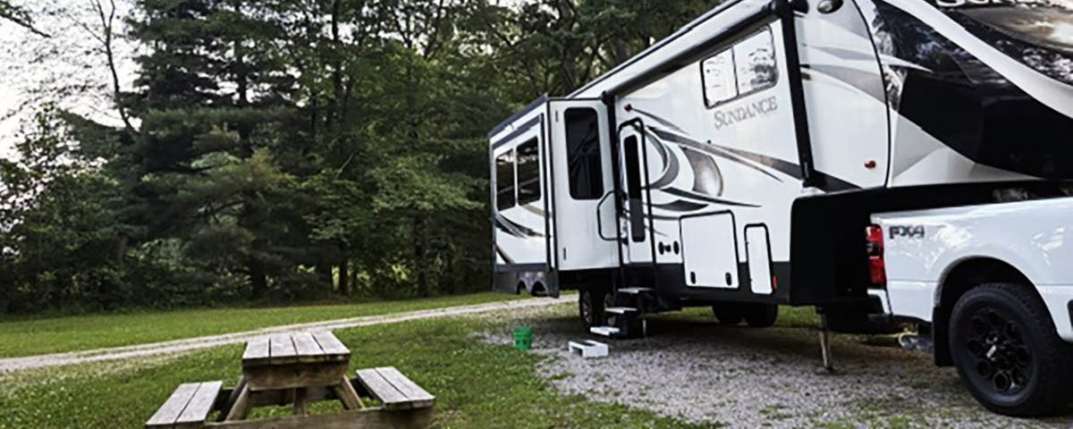 RV campsite surrounded by mature trees at Woods-N-Waters Kampground near Columbus, Indiana.